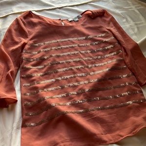 Beautiful top with sequence detail in the front. See thru in the back.